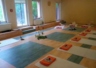 Seminarraum für Schweige-Retreats mit Sitzplätzen und vorbereiteter Mitte