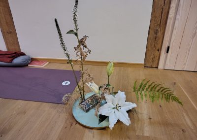 Blumenarrangement im Seminarraum während eines Schweige-Retreats zum Thema Wandel und Vergänglichkeit