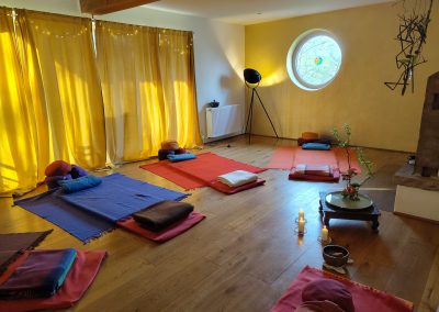 Vorbereiteter Raum für Breathwork mit Matratzen, Kissen und warmer Beleuchtung