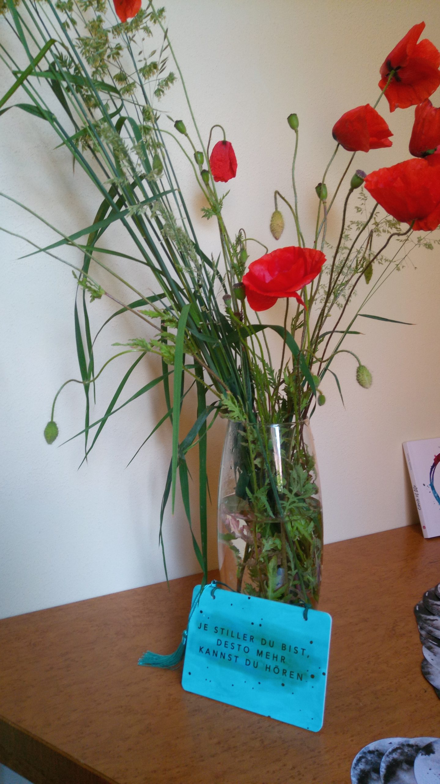 Vase mit wilden Blumen auf einem Tisch, als stiller Moment von Achtsamkeit und Einfachheit