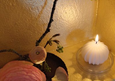 Kerze und Blumendekoration im Seminarraum einer Breathwork Atemsitzung während des Retreats