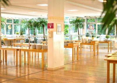 Heller Speisesaal im Yoga Vidya Ashram mit vegetarisch-veganer Verpflegung für Retreat-Teilnehmende.