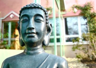 Buddha-Statue im Garten eines Seminarhauses für Schweigeretreats.